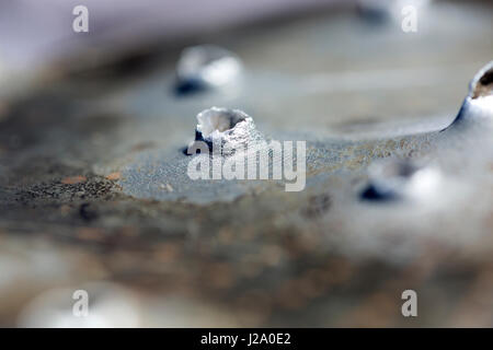 Macro shot of bullet holes after a target shooting in a aluminum pan. Stock Photo