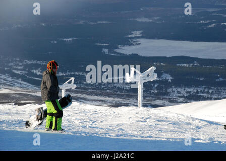 A snowboarder looks out over Loch Morlich from the slopes of Cairngorm. File Photo. Stock Photo