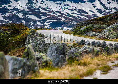 Gravel road on Hardangervidda, Norway, an autumn day with snow on the mountain tops. Stock Photo