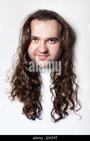 Funny men's head, hair with long curly hair. Close-up on a white background head. Stock Photo