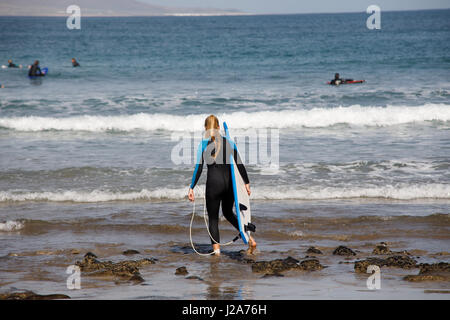 Surfers are waiting for the perfect wave at Famara, Lanzarote. Stock Photo