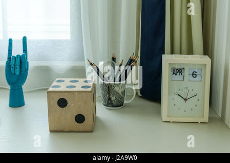 decorative table with pencils and clock in room Stock Photo