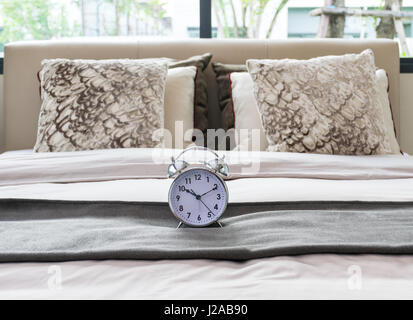 classical alarm clock on bed Stock Photo