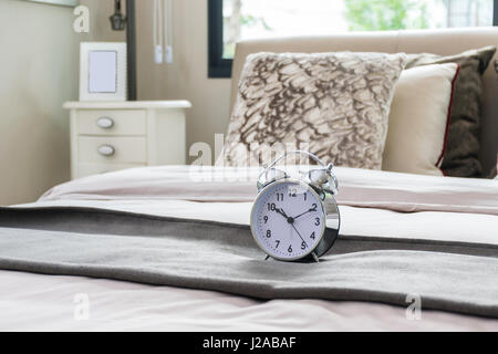 classical alarm clock on bed Stock Photo