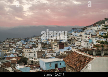 Morocco, Chefchaouen or Chaouen is the chief town of the province of the same name. It is most noted for its small narrow streets and neighborhoods painted in variety of vivid blue colors. Range of the Rif Mountains in the Background. Stock Photo