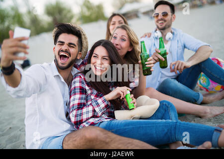 Happy friends partying and having fun on beach at summer Stock Photo