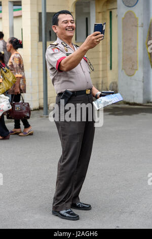 Indonesia, Sumatera Utara, Kabul Langkat, policeman photographed tourists Stock Photo