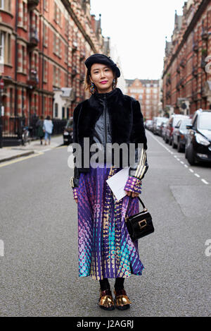 LONDON - FEBRUARY, 2017: Full length view of woman standing in street after leaving Sharon Wauchob fashion show, London Fashion Week, day four. Stock Photo