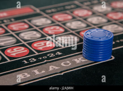 gambling on a roulette table with blue chips Stock Photo