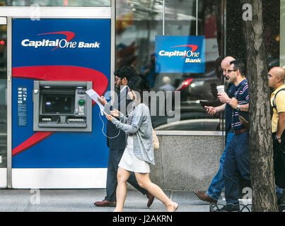 Capital One ATM on the streets of Manhattan with people walking by. Stock Photo