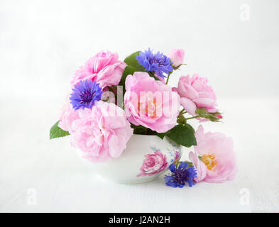 Colorful bouquet of light pink roses and cornflowers on pale  grey  background. Stock Photo