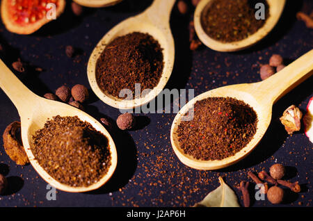 Closeup wooden rustic spoons filled up with fresh herbal tea powder, other teas and spices in background, very nice arrangements Stock Photo