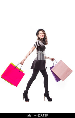 Colourful shopping vibes. Full length portraits of smiling brunette woman in hat with shopping bags Stock Photo