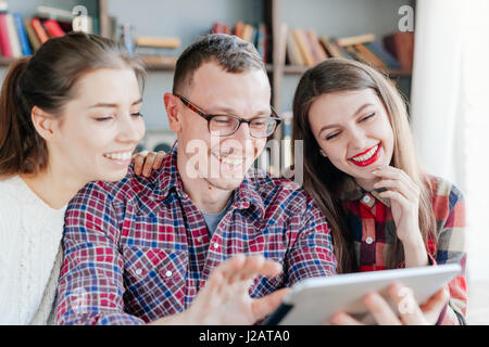 Hipster friends looking at their selfie on tablet. Stock Photo