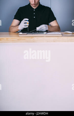 Midsection of young male technician repairing digital tablet at electronics store Stock Photo