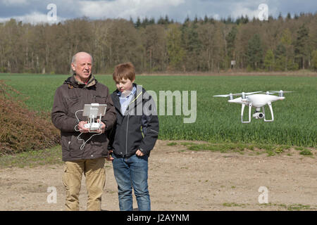 man flying drone, teenage boy watching Stock Photo