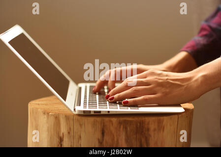 Women hands writing on a keyboard on a wooden table, vintage style. Stock Photo