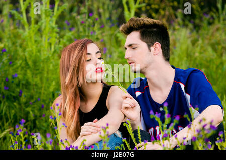 Portrait of romantic couple. Young woman smelling Daisy flower Stock Photo