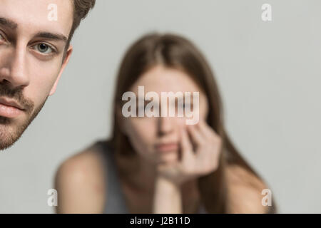 Cropped portrait of young man with woman in background Stock Photo