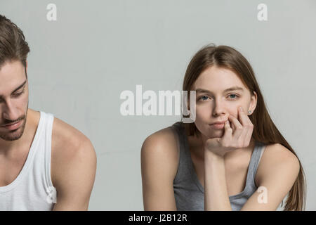 Thoughtful woman sitting with man against gray background Stock Photo