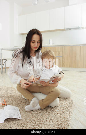 Mother and son sitting on floor Stock Photo