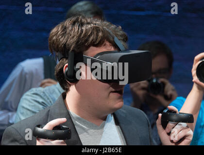 Oculus Founder Palmer Luckey wears the Oculus Rift consumer version Virtual Reality goggles and holds the Oculus Touch prototype during a demonstration at the Silicon Valley Virtual Reality Expo June 11, 2015 in San Jose, California. Stock Photo