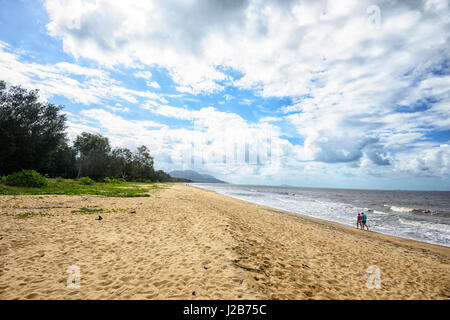 Two persons walking on the beach at Bramston Beach, Far North Queensland, QLD, FNQ, Australia Stock Photo