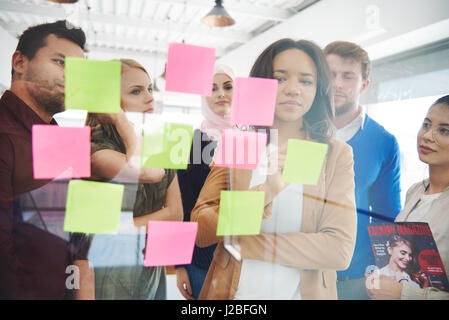 Business people putting ideas on adhesive notes Stock Photo