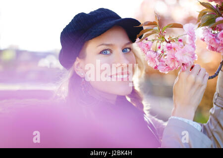 Young woman holding cherry blossom in park Stock Photo