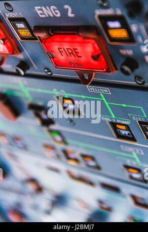 Fire pushbuttons and warning lights on the overhead panel in an Airbus A320 cockpit. Bright red warning lights come on when a fire is detected in one  Stock Photo