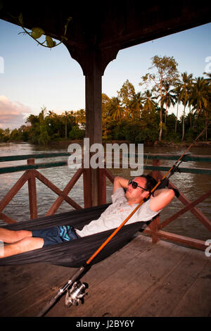 Don Det is part of the 4,000 islands, the stunning region at the southern tip of Laos. A traveler relaxing in a hammock. (MR) Stock Photo
