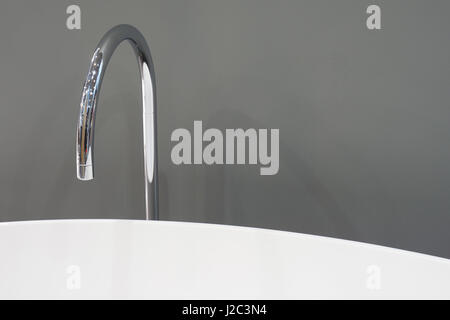 White bath and water tap on gray background Stock Photo