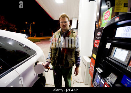 young man filling in the car tank at a gas station Stock Photo