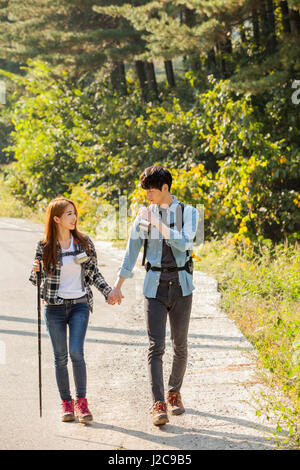 Smiling couple trekkers walking hand in hand outdoors Stock Photo - Alamy
