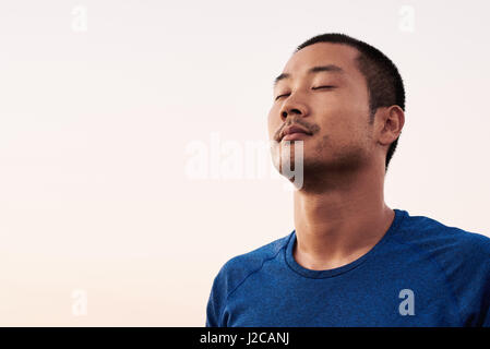 Handsome Asian man relaxing after morning run Stock Photo