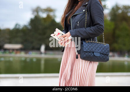 Woman in pleated skirt with designer handbag horizontal crop Stock Photo