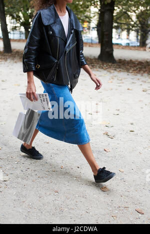 Woman in oversized leather jacket walking in park, crop Stock Photo