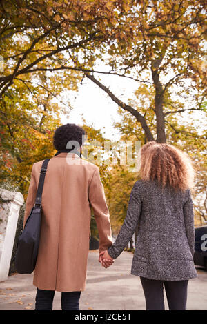 Rear View Of Romantic Couple Walking Hand In Hand Along Country Lane At ...