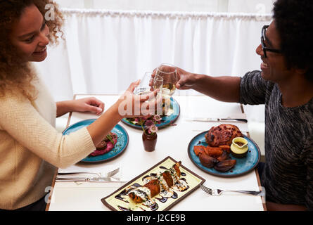 Overhead View Of Couple Making Toast On Date In Restaurant Stock Photo