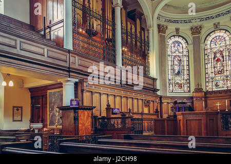 Saint Annes Church in Manchester, UK. Side view of benches, organ and beautiful mosaic windows Stock Photo