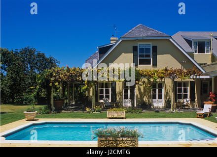 Outdoor swimming pool in front of patio. Stock Photo
