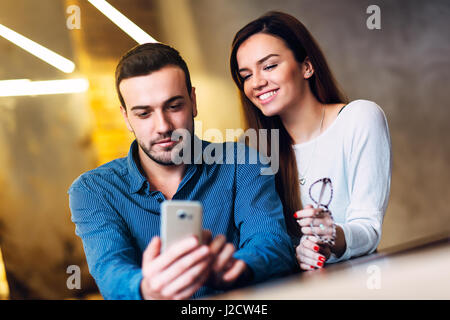 Happy young couple browsing the internet at the smart phone. Stock Photo