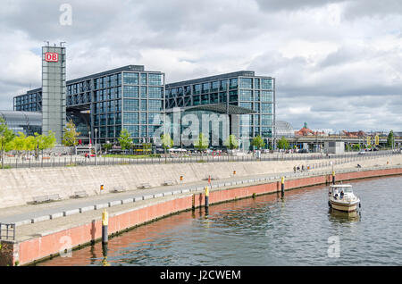 Berlin, Germany - August 14, 2016: View of the Berlin Central Station (Berlin Hauptbahnhof) with its curved glass roofs,  and people enjoying the clou Stock Photo