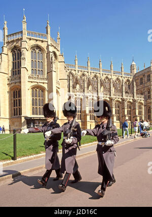 St Georges Chapel Windsor Castle Berkshire England UK British Army Grenadier guardsmen soldiers marching in winter uniform with Bearskin hat & plume Stock Photo