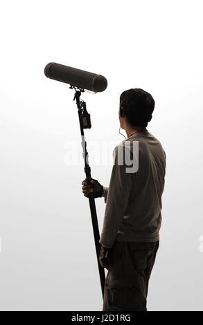 Boom Microphone hold up high by video or film production crew team man and recording sound for movie in a big studio. Stock Photo