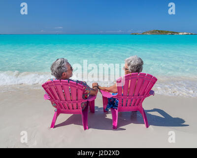 Bahamas, Little Exuma Island. Senior couple sitting on beach. Credit as: Don Paulson / Jaynes Gallery / DanitaDelimont.com (MR) Stock Photo