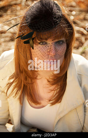 Beautiful ginger haired girl wearing a fascinator - head shot Stock Photo