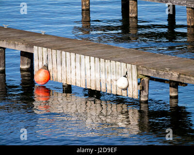 wood dock with round floats, reflections and copy space Stock Photo