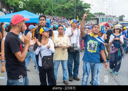 A group of young people shout slogans for the release of political prisoners, in protest of the opposition on a main highway in Caracas on Monday, April 24th, the Venezuelan opposition launched a new protesting strategy: a National Sit-In. The objective is to achieve a “higher level of pressure” by blocking the main avenues and highways of the country and staying in place for hours Stock Photo