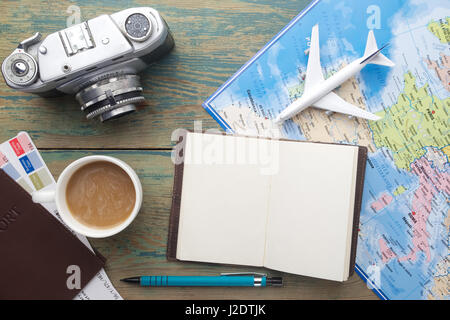 Travel , trip vacation, tourism mockup - close up note book, vintage camera, toy airplane and touristic map on wooden table. Empty space you can place Stock Photo